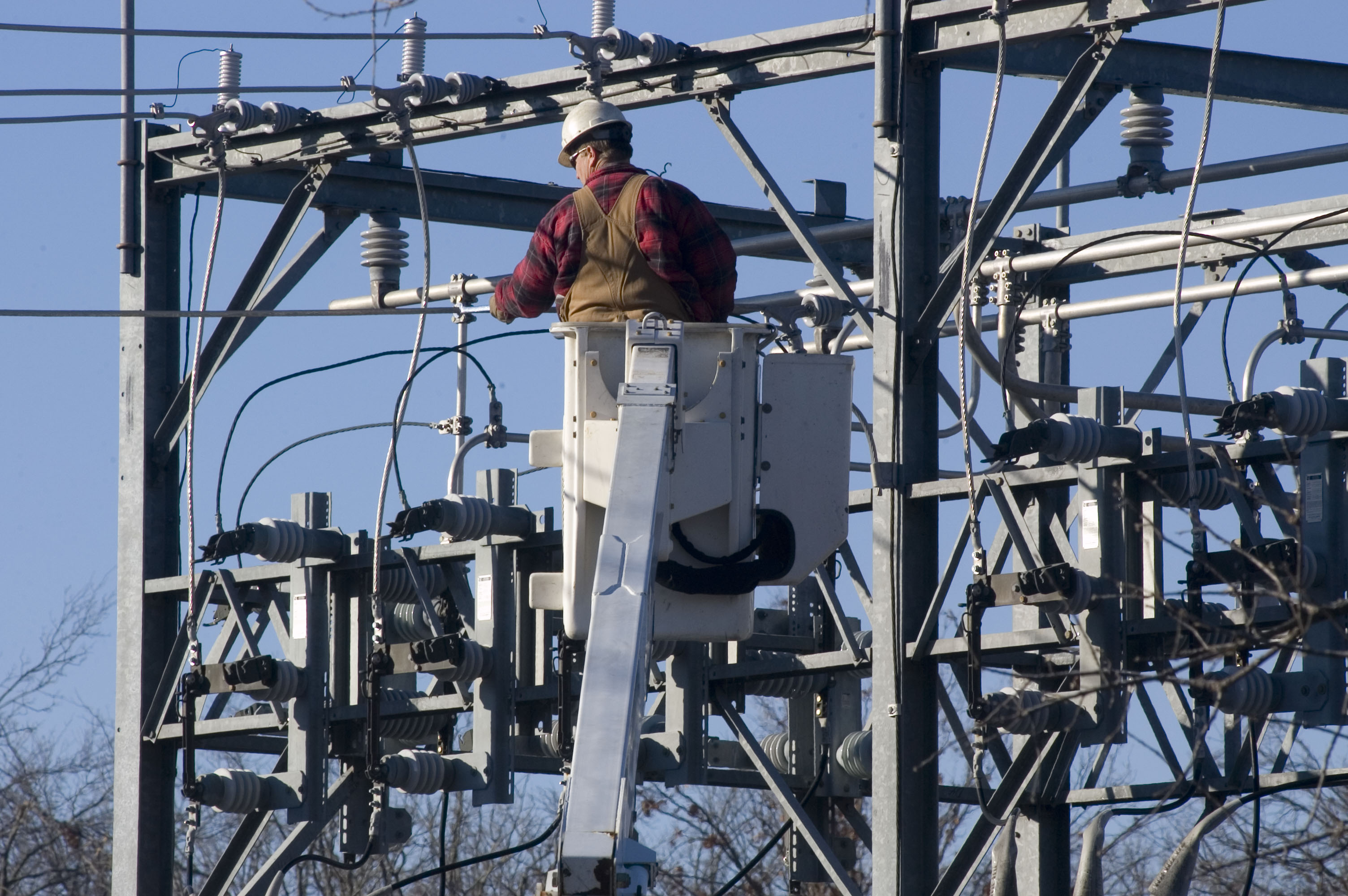 man in bucket lift working on substation