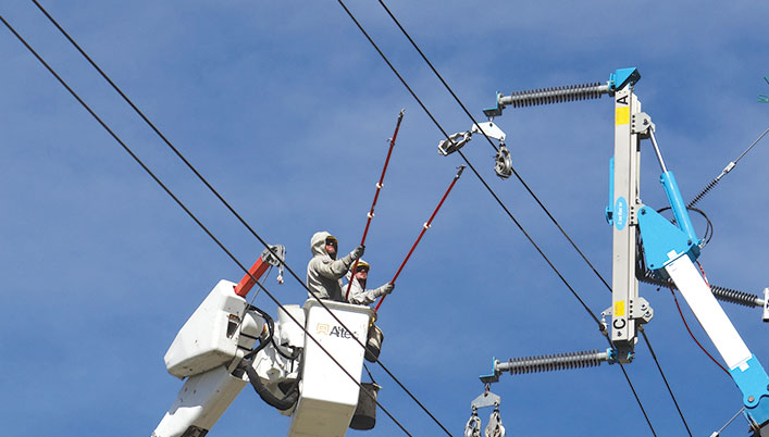 man in bucket lift working on power line with grounding pole